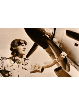 Frank Carey aviateur britannique, portant une montre vintage à son poignet. Il pose devant son avion de chasse Hurricane Hawker